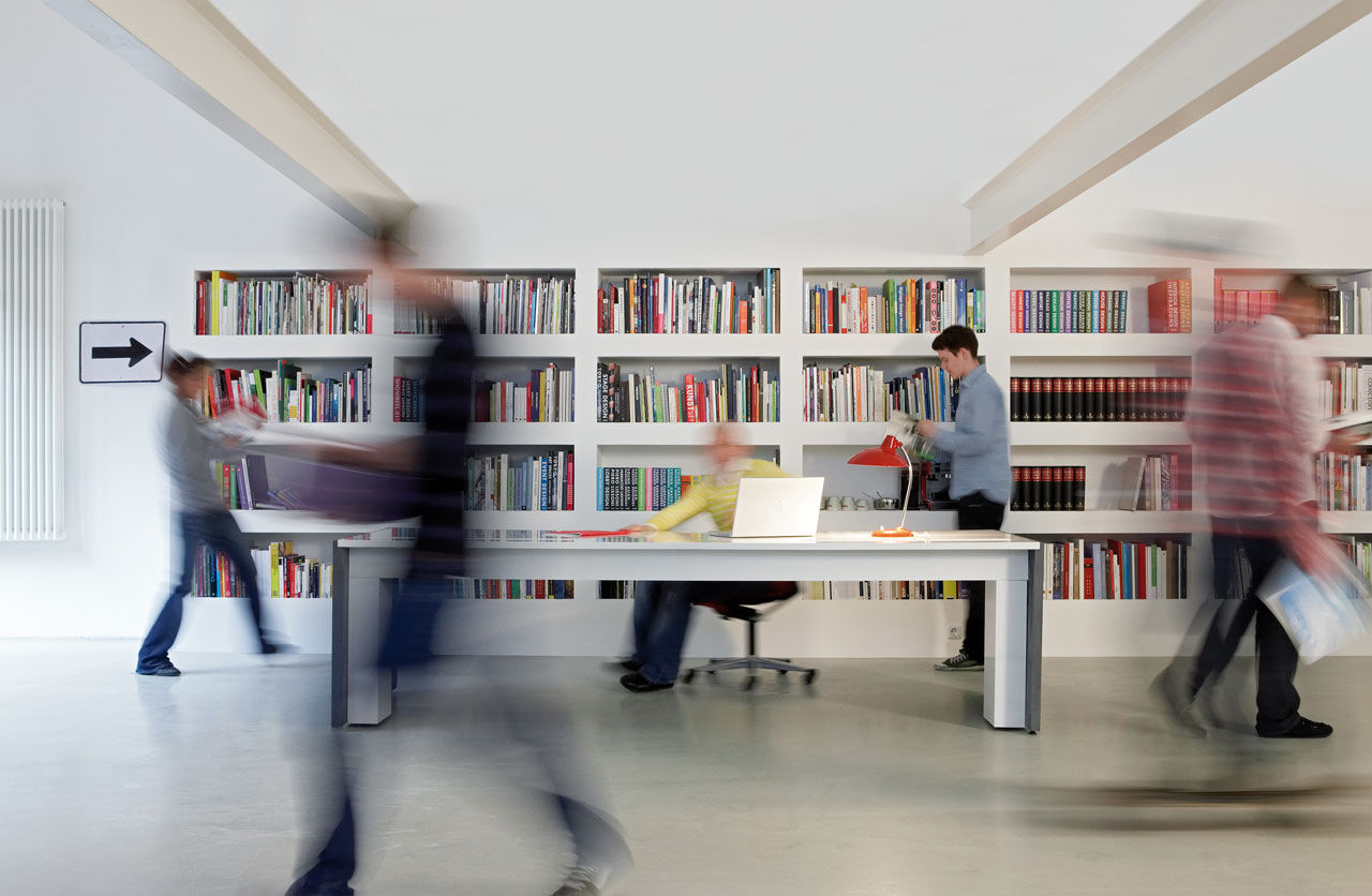 Büro mit raumlanger Regalwand unter Dachbalken